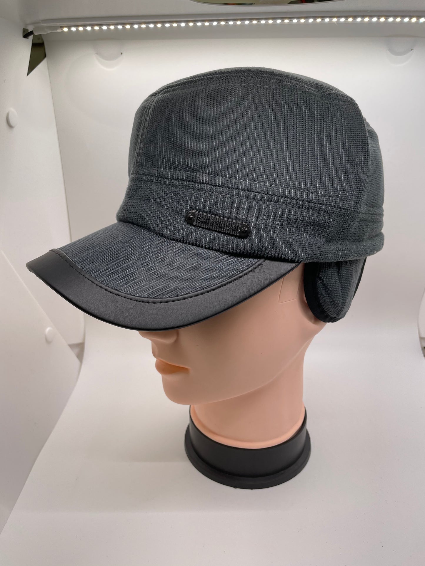 "Gray winter hat with ear flaps and a ribbed knit texture"