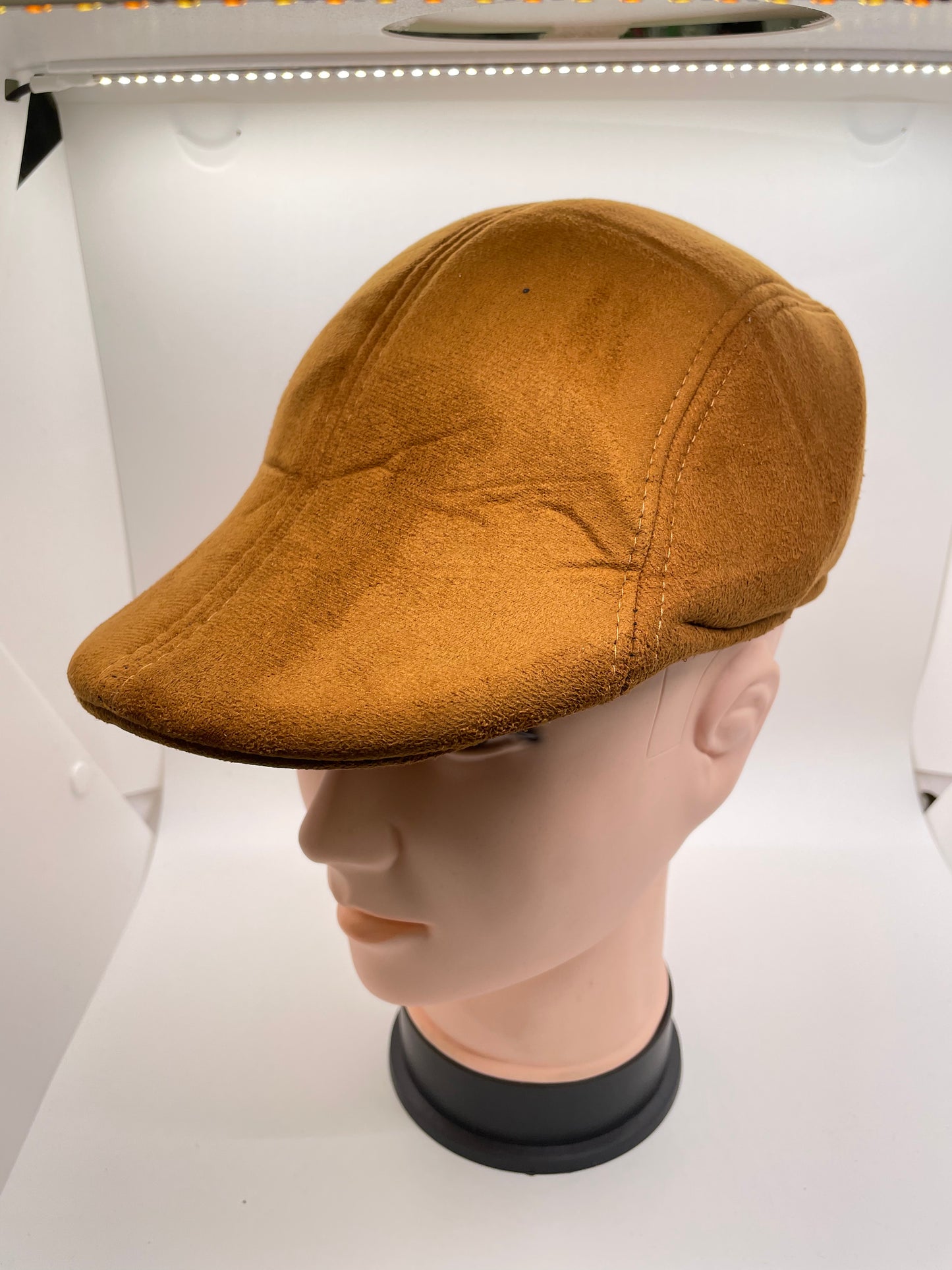 Brown flat hat with a ribbed knit texture and a buckle closure