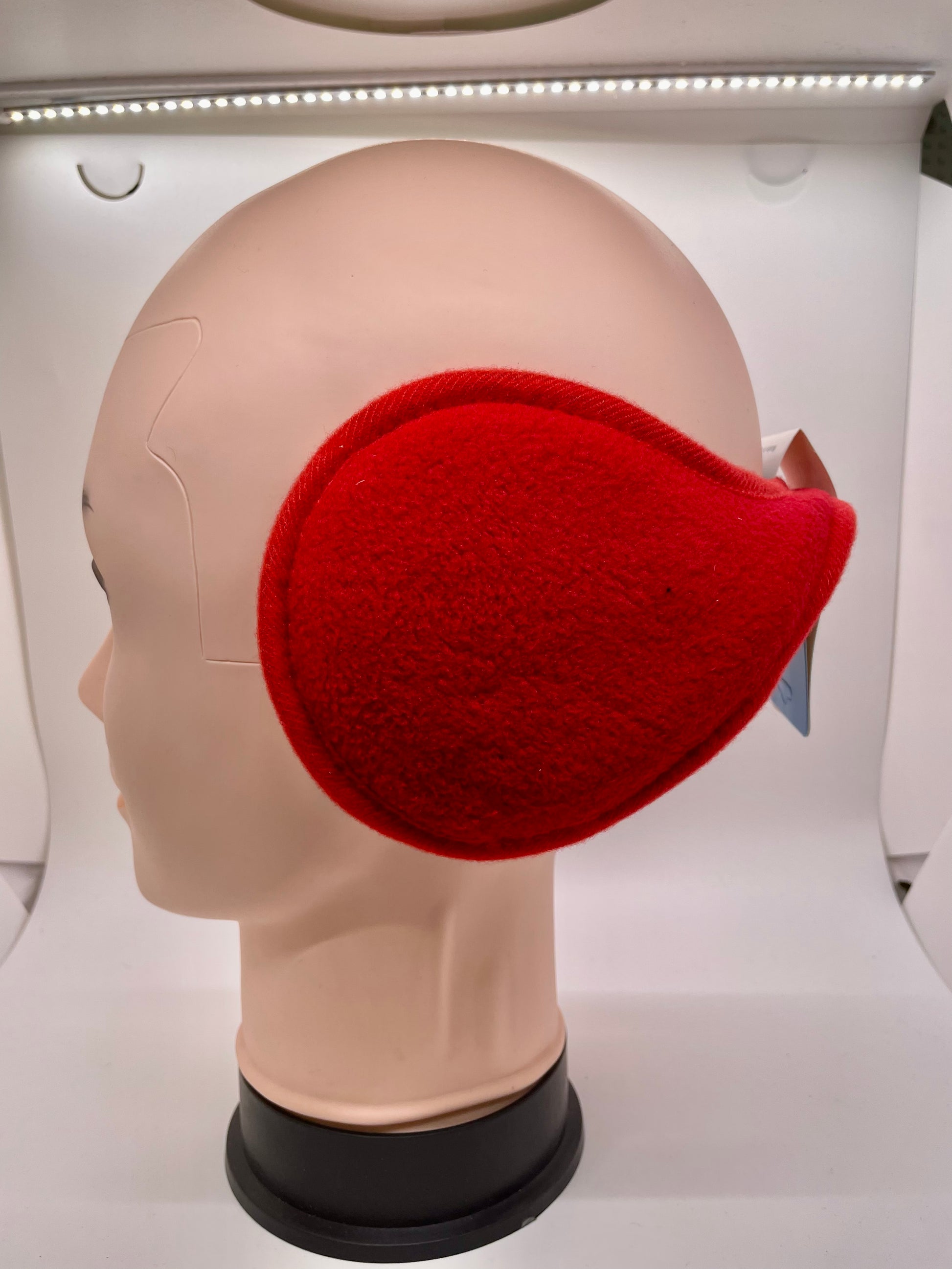 Red ear muff with a plush texture and a bow detail