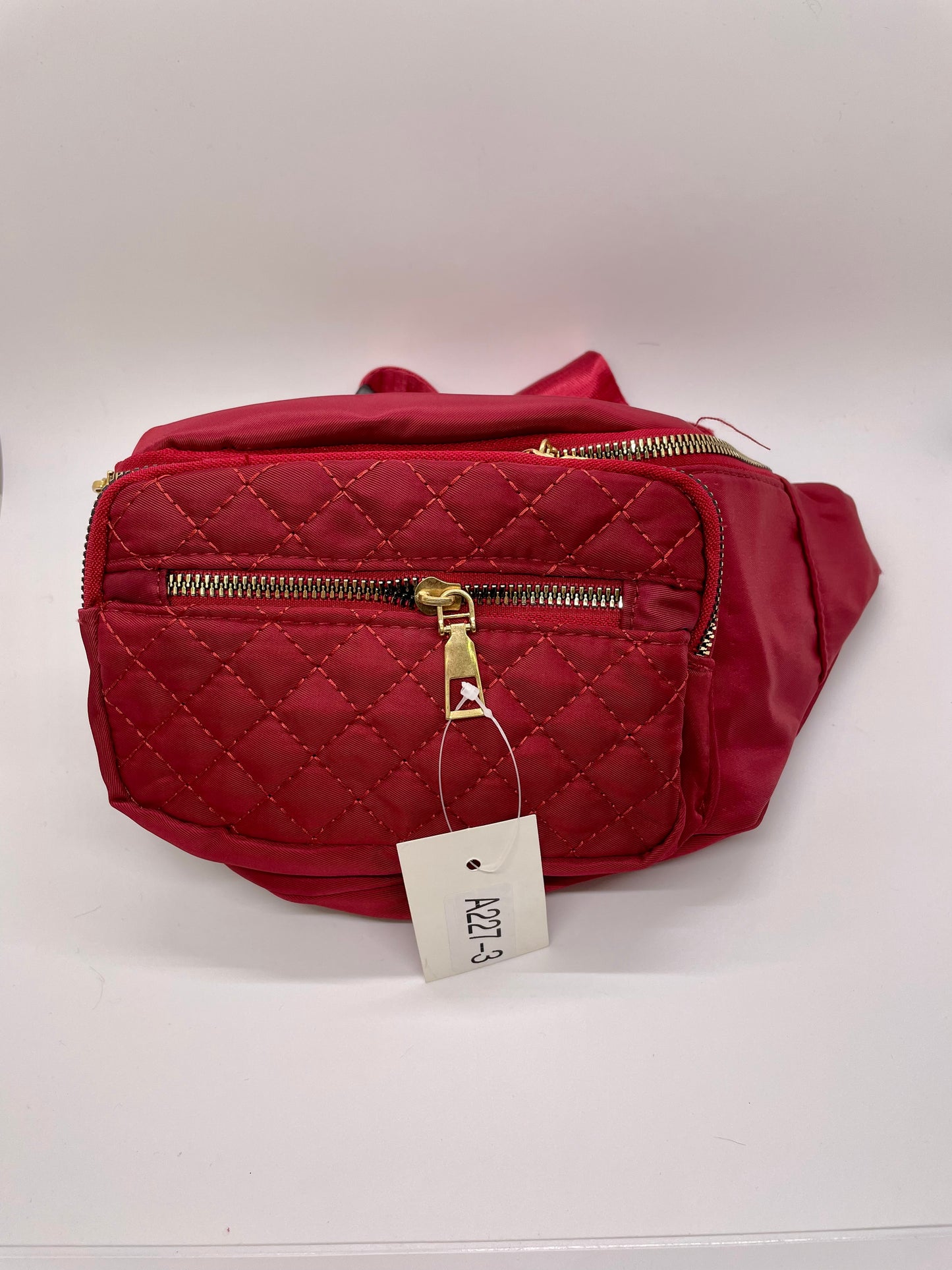 Red fanny pack with a quilted texture and a buckle closure