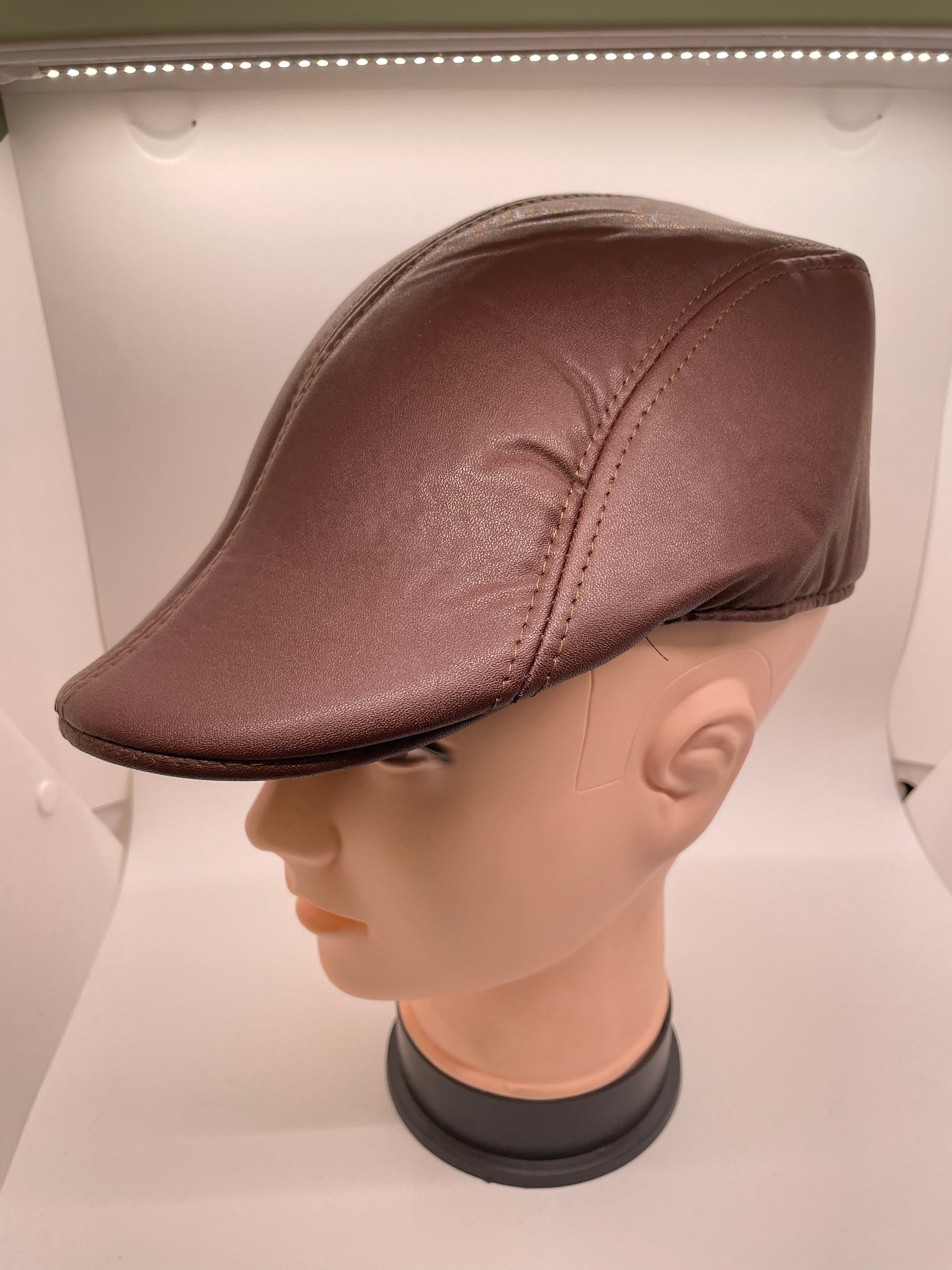 "Gray leather flat hat with a padded headband and a stretchy fit"